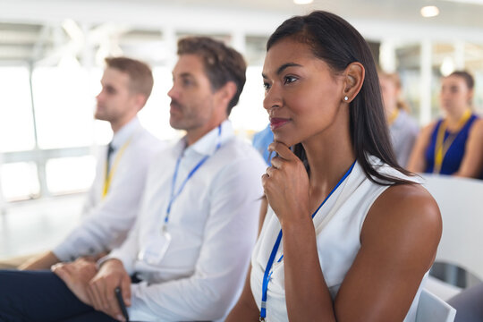 Businesswoman listening to speaker in business seminar