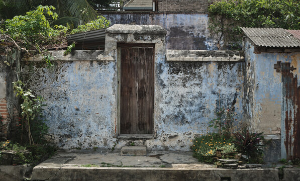 Old Nanyang Chinese House Rear Entrance with Wooden Door and Weathered Blue Wall