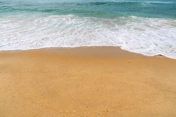 Gentle ocean waves washing over golden sand on a sunny beach in France, creating a peaceful coastal scene for summer travel and relaxation themes © Ilja