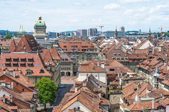 Panoramic view of the historic city center of Bern in Switzerland featuring traditional red tiled roofs and the iconic Federal Palace dome building