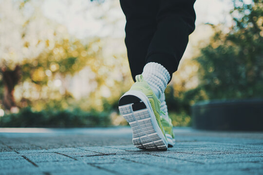 Walking Forward in Sport Sneakers with Green Bokeh