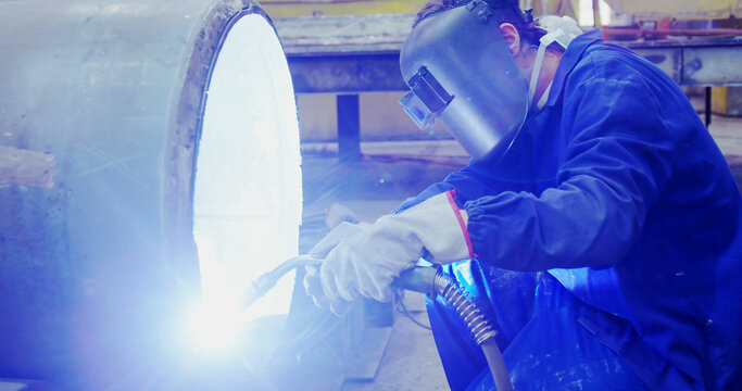 Welder in action at an industrial site, with copy space