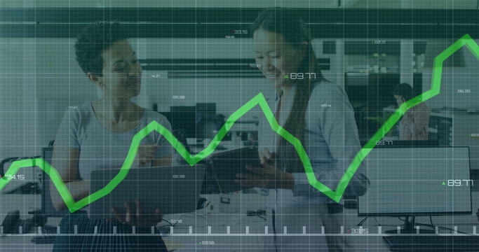 Diverse businesswomen collaborate with tech in a modern office, symbolizing global connections.