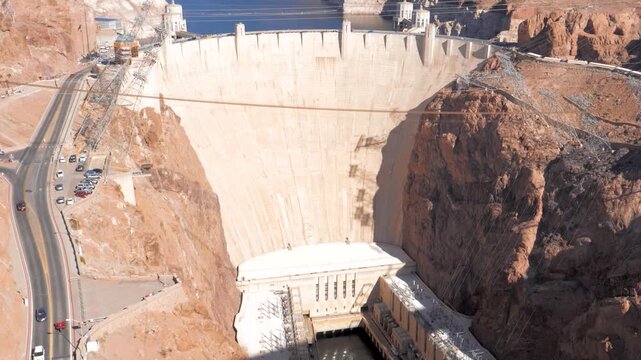Hoover dam spanning black canyon and holding back lake mead on nevada arizona border, with its concrete wall, hydroelectric infrastructure, and desert landscape under bright sunshine