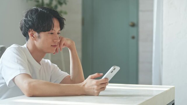 A man smiling while using his smartphone. Apps, social media, videos, games, relaxation, search, web, DX, AI, streaming.