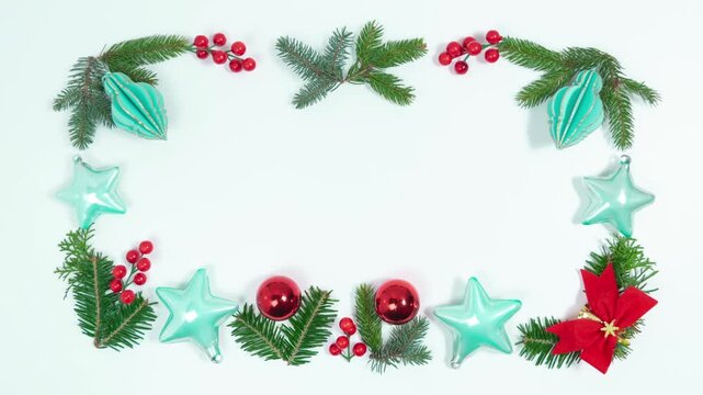 Christmas Flat Lay Frame Background with Fir Tree Branches, Red Berries, Mint Star Ornaments, and Red Baubles on White Copy Space