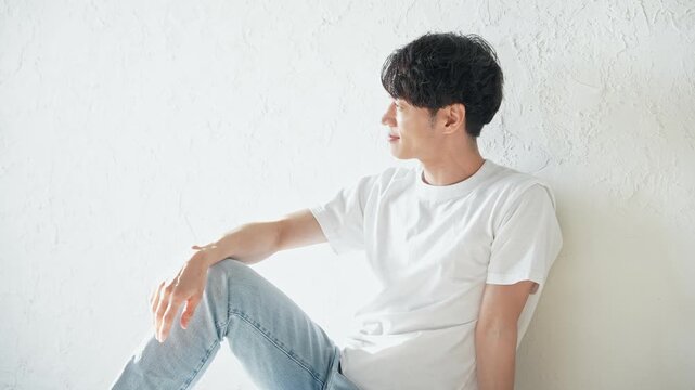 床に座ってリラックスする若い男性。メンズ、美容、ボディケア、スキンケア、エステ、爽やか、イケメン