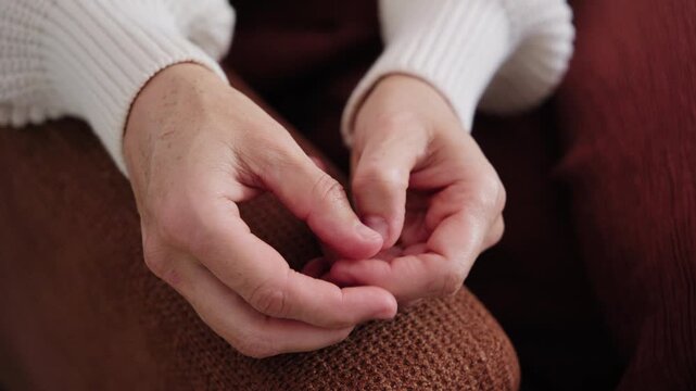 Close-up of a woman nervously fidgeting with her hands and picking at her nails, showing signs of anxiety, stress, and emotional tension.