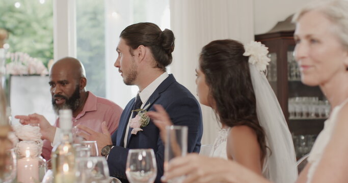 Guests at wedding reception enjoying conversation and drinks at elegant table