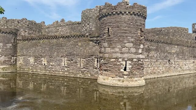 Stone towers and a still moat at Beaumaris Castle on the Isle of Anglesey