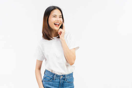 Happy young Asian woman touching cheek and smiling on white background, skincare and beauty concept.