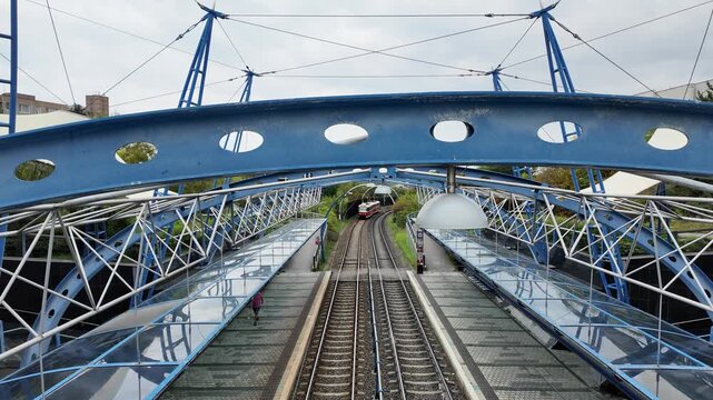 Tram Approaching Elevated Station with Passengers on Platforms