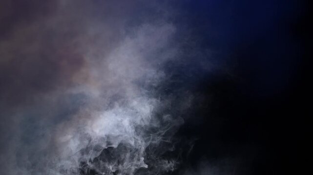 Dense fog moves through the frame at night with studio lighting creating visible smoke patterns against a black background