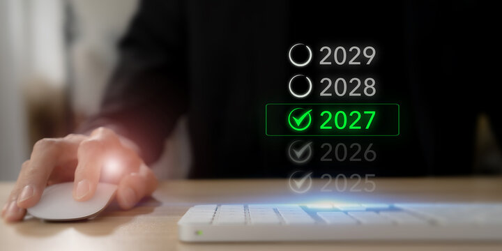 2027 Year Selection Concept. Business Planning, Future Strategy and New Year Goals. Selecting 2027 on a virtual timeline with green checkmark. New year planning, future goals and business progress.