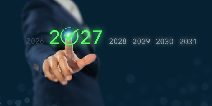 2027 Year Selection. Future Business Strategy, Planning and Success Concept. Touching glowing green 2027 with checkmark on digital timeline from 2026 to 2031. Future planning and business decisions.