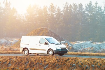 White delivery van driving on quiet country road © AlexGo