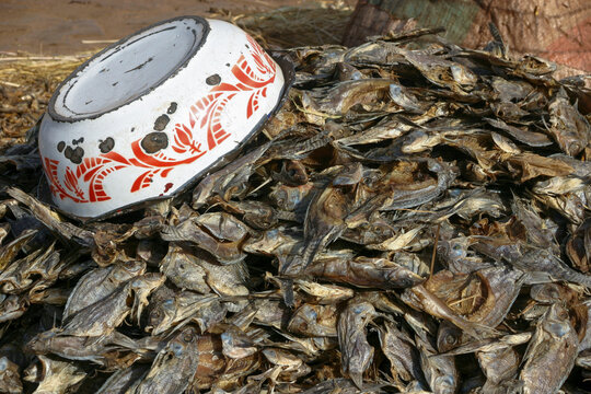 Pile of dried fish with an enamel bowl turned upside down on top for sale at the market, Mopti Region, Mopti, Mali