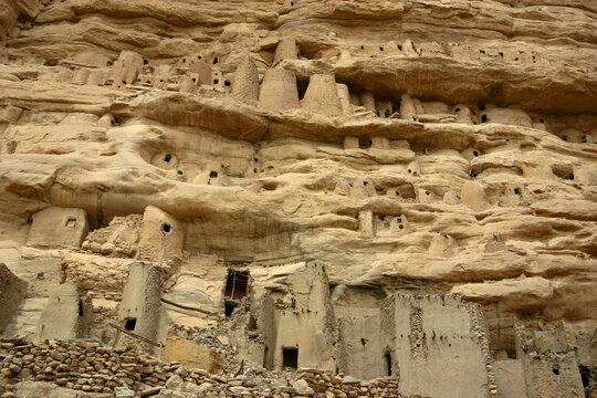 Abandoned mud dwellings and tombs stacked in layers of the cliff face, Mopti Region, Bandiagara, Mali