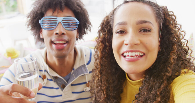 Image of happy diverse couple celebrating new years eve and making image call