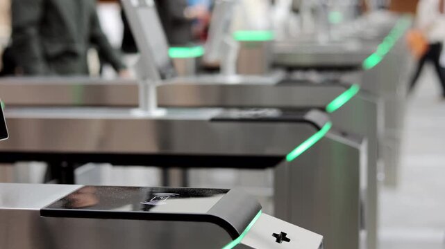 Modern automated access control turnstiles with RFID contactless card readers and biometric security terminals in a public building, illustrating smart entry systems and identity verification.
