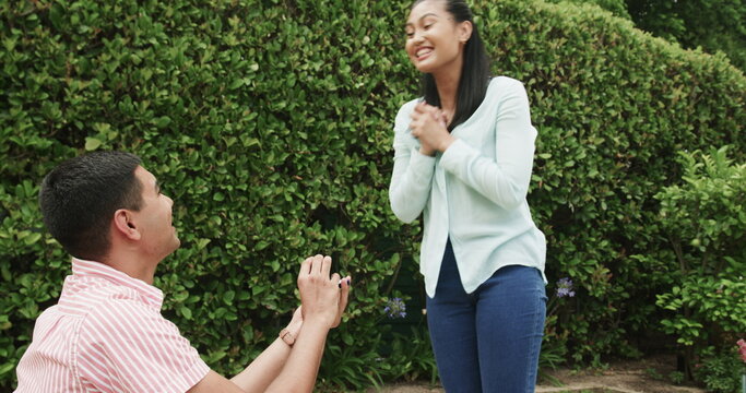 Young couple enjoying playful moment together in lush green garden setting