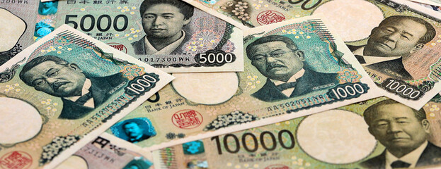 Japanese yen money banknotes pile on table. Japan bills of JPY currency. Concept of economy © Larysa