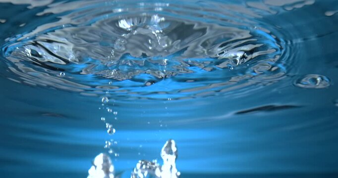 Ice cube dropping into water creating splash closeup slow motion 1000 fps