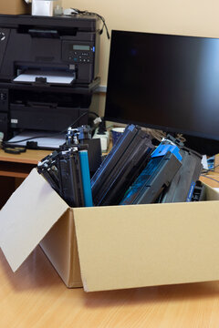 Box of used toner cartridges for recycling in office environment