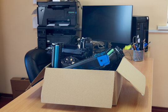Box of used toner cartridges for recycling in office environment