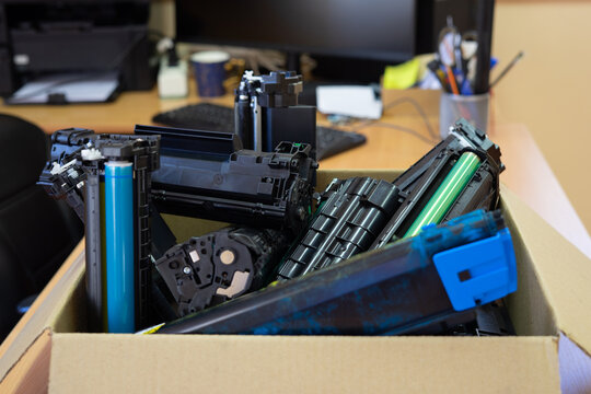 Box of used toner cartridges for recycling in office environment