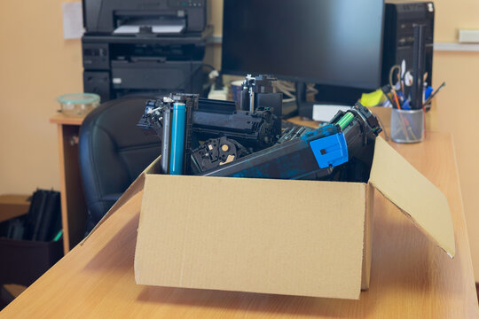 Box of used toner cartridges for recycling in office environment