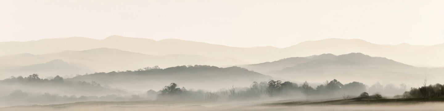 panoramic misty mountain landscape soft morning fog rolling hills serene nature background minimal beige monochrome panorama peaceful countryside view calm horizon outdoor landscape photography
