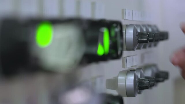 Technician machine operator hand adjusting switches dial on a PLC industrial machinery control panel with various buttons switches in an automated factory, industrial automation, smart manufacturing