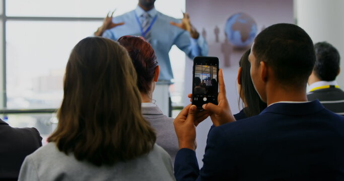Front view of an African american male speaker speaking to the public in a business seminar 4k