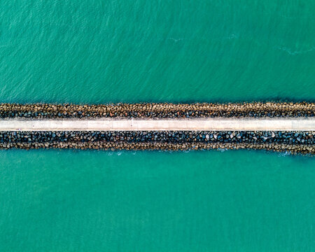 Aerial top down view of breakwater jetty and turquoise sea in Saint-Gilles-Croix-de-Vie France

