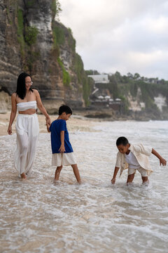 Asian family enjoying a summer vacation and playing together on a tropical beach