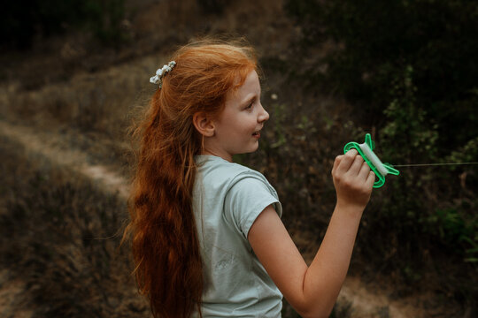 Redhead girl holding kite string reel