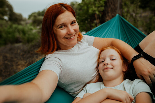 Mother and daughter cheek to cheek in hammock