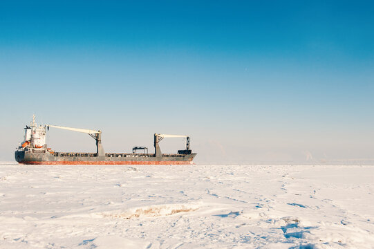 Winter shipping. Big cargo ship icebreaker in frozen sea fairway