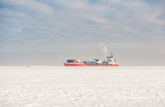 Winter shipping. Big cargo ship icebreaker in frozen sea fairway