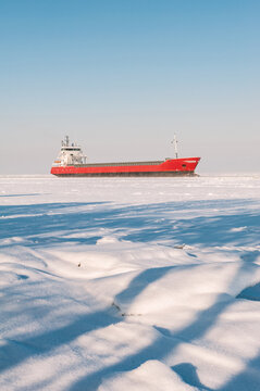 Winter shipping. Big cargo ship icebreaker in frozen sea fairway