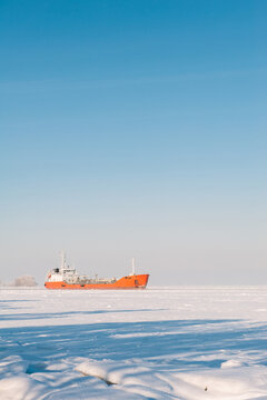 Winter shipping. Big cargo ship icebreaker in frozen sea fairway