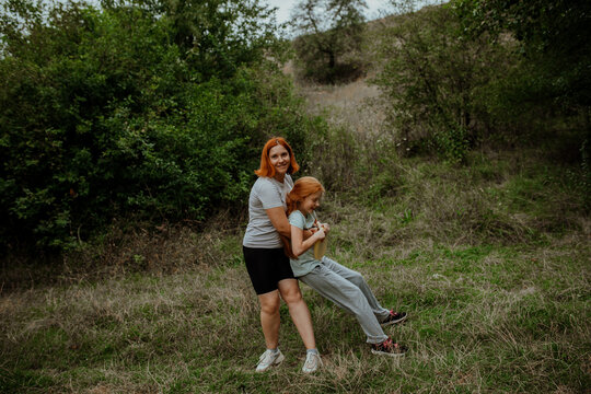 Mother and daughter playing frisbee in meadow