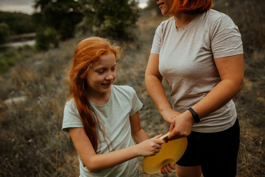 Mother and daughter holding frisbee together