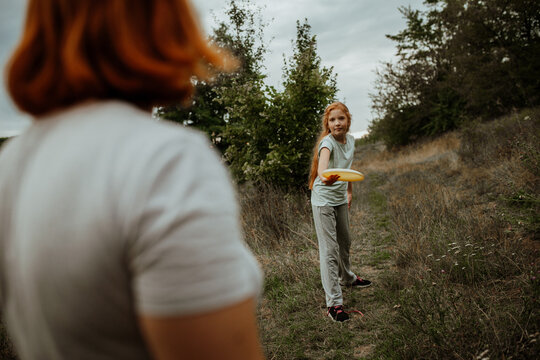 Girl holding frisbee in field, over shoulder view