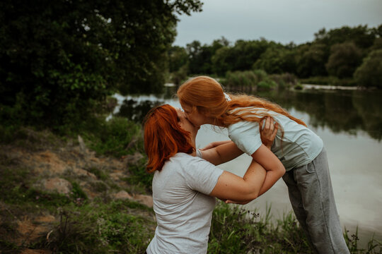 Mother and daughter hugging by the lake