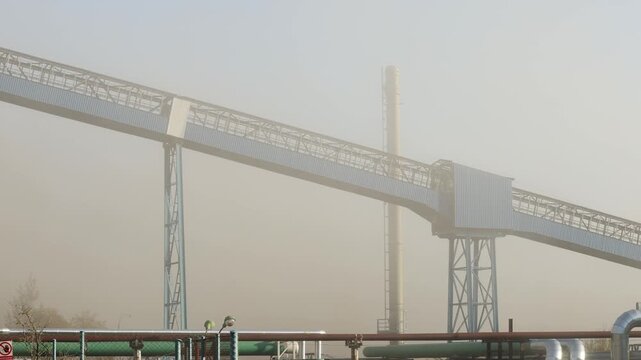 Thick clouds of dust and smoke engulf an industrial demolition site after a controlled explosion brings down a massive coal mining tower, illustrating industrial decline and decommissioning.
