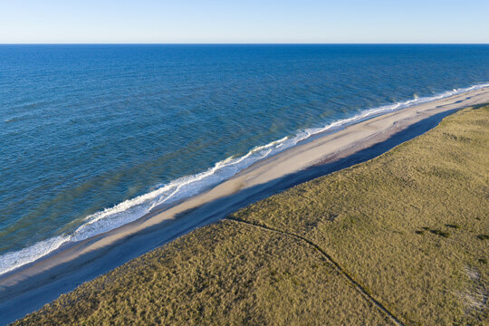 Gentle waves from the North Atlantic Ocean wash against Nauset Beach in Orleans, Cape Cod, Massachusetts. This beautiful area is a popular east coast vacation destination during summer months.