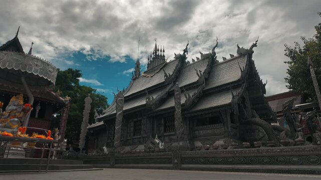 timelapse intricate Silver Temple architecture displaying carved metal relief, detailed Chiang Mai buddhist shrine Wat Sri Suphan exterior featuring traditional asian handmade ornament, 4k hyperlapse