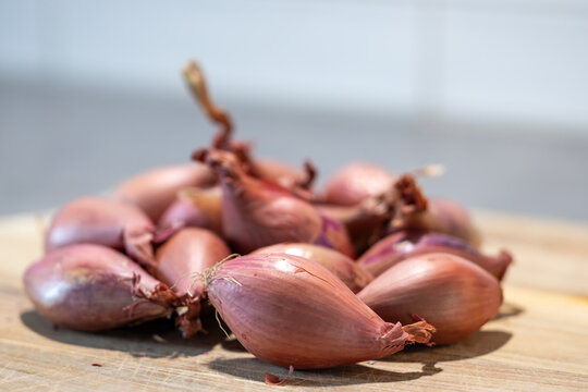 Stockholm, Sweden Shallots or onions on a wooden board.